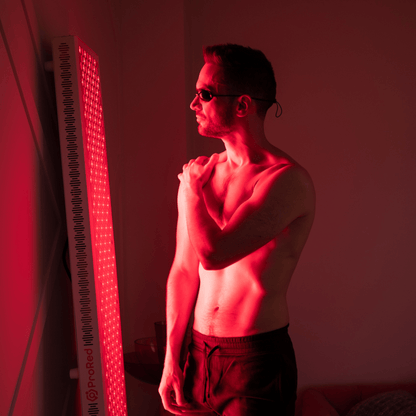 man using red light therapy to help shoulder pain