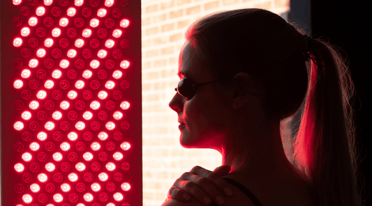 Lady sat in front of a red light therapy panel