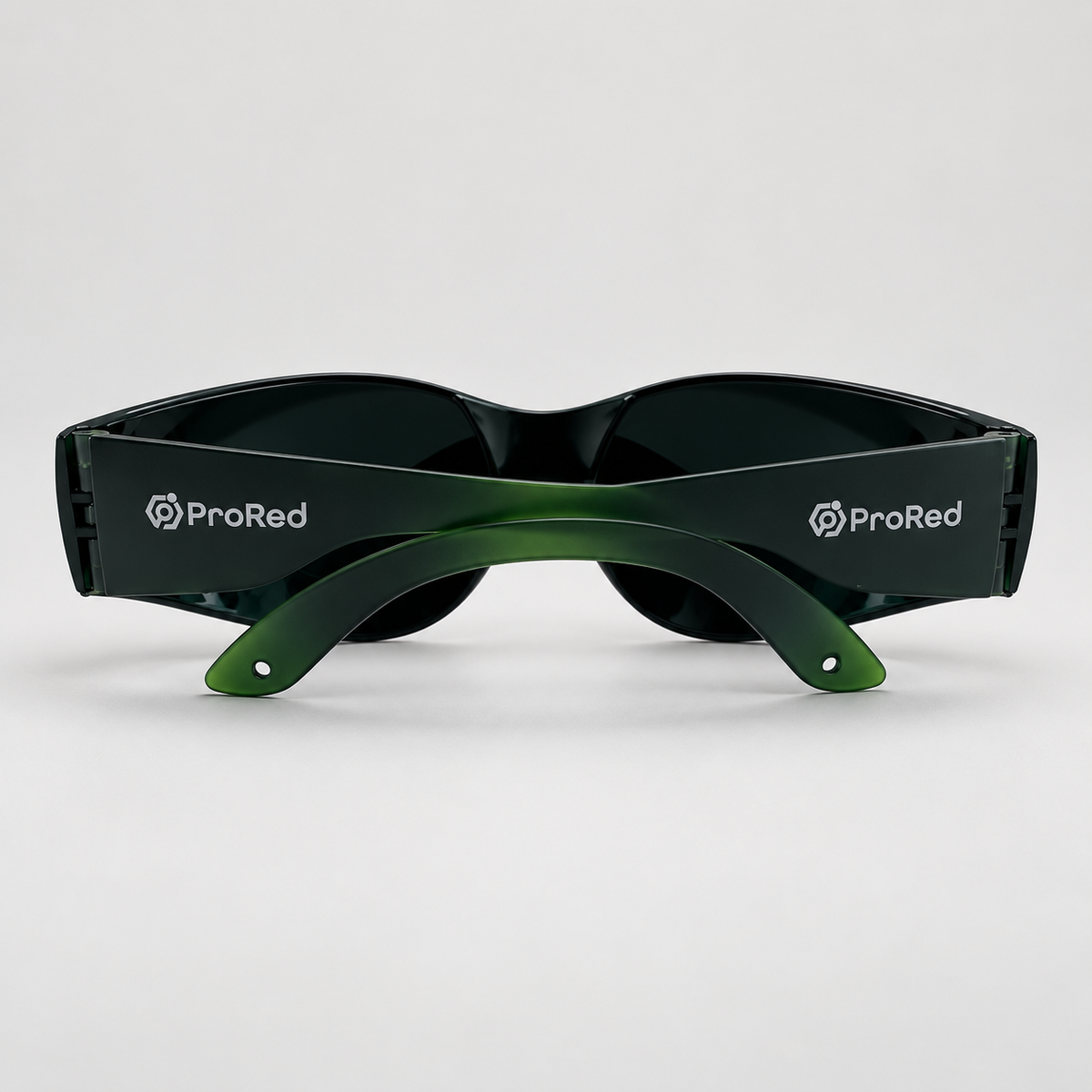 A pair of wraparound sunglasses with dark lenses and a translucent green temple arm, featuring the white ProRed logo on both sides, set against a light gray background.